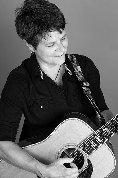 photo of Tret Fure playing her guitar